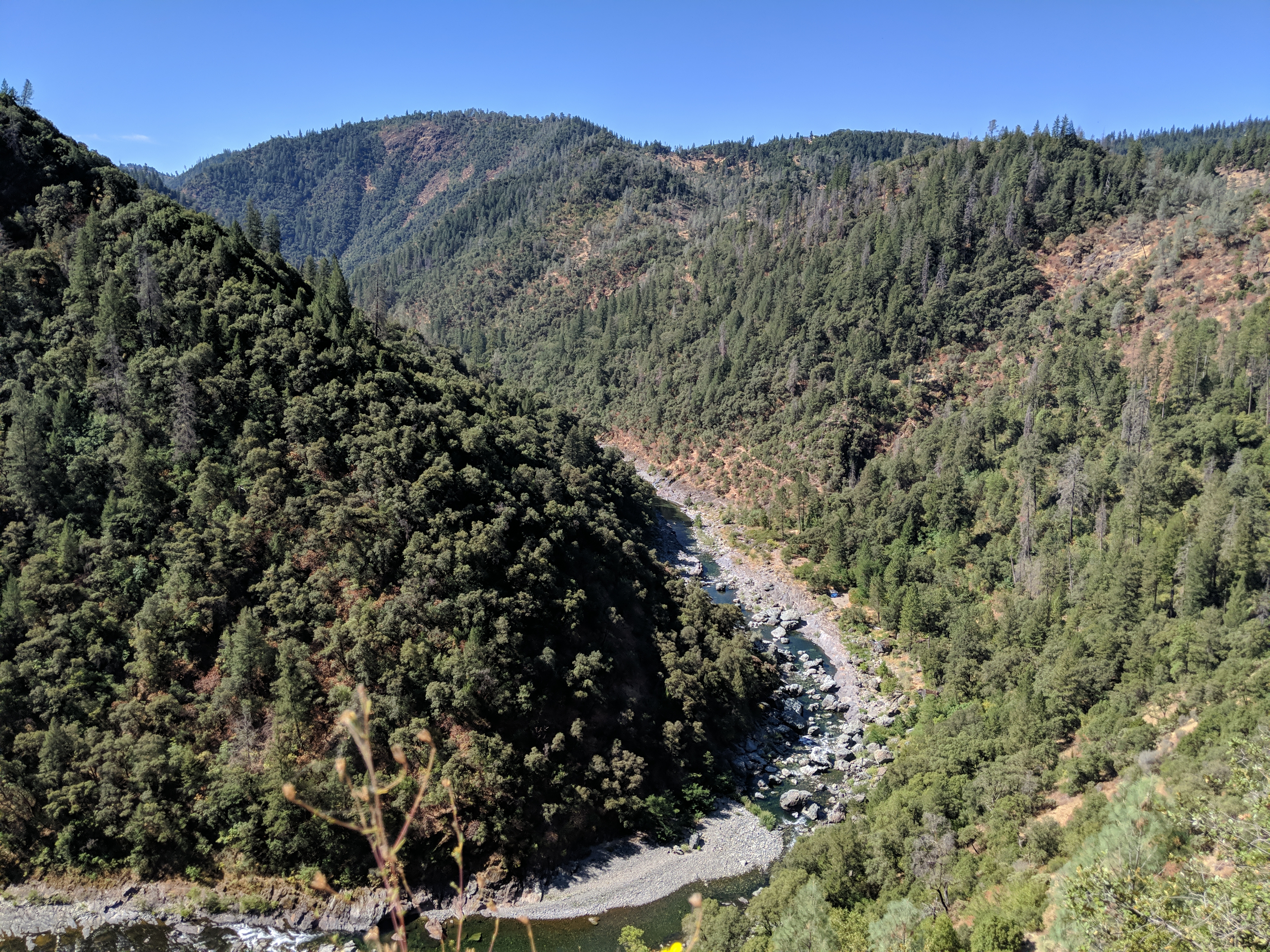 river curving around hill with tent in corner